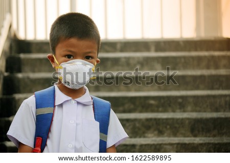 Asian student boy wearing dust mask 
 and air pollution with pm 2.5 at Bangkok, Thailand Royalty-Free Stock Photo #1622589895