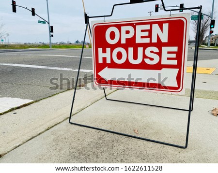 Open house sign on a sidewalk in semi-rural area.