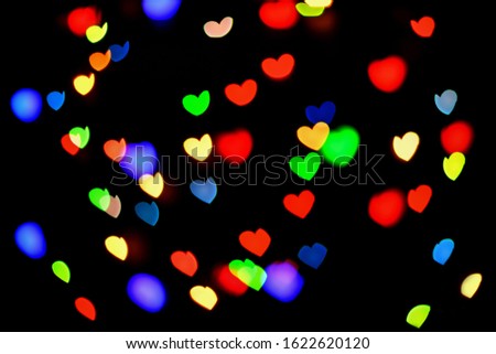 Abstract bokeh hearts on black background. Valentines day. Blurred background