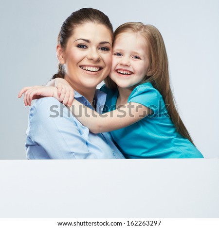  Mother and daughter embrace. Business woman with kid girl. Isolated studio  portrait behind white board. Female model.