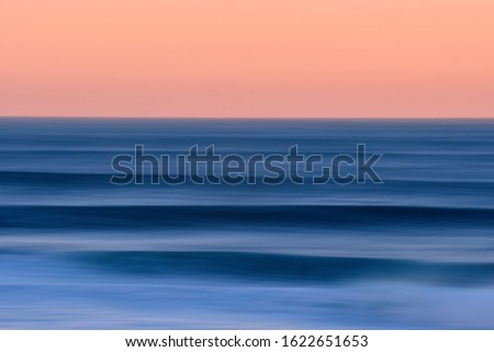 motion blur of swell lines hitting the coast at sunrise