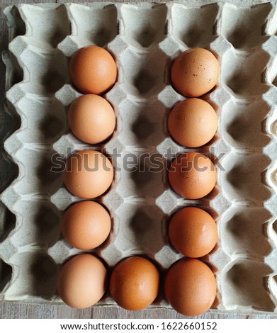 Close-up view of raw brown chicken eggs in egg box on wooden background with "I love You" collection as "U" alphabet for valentine day