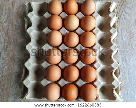 Close-up view of raw brown chicken eggs in egg box on wooden background with "I love You" collection  as "I" alphabet for valentine day