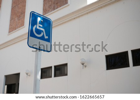 Signpost for disabled people, wheelchair parking sign in the park