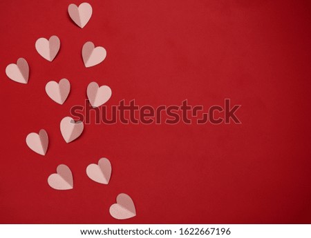 Hearts made of paper on a red background, top view. Red background with hearts for Valentine's day or wedding. 