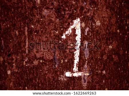 Hand written number one on red color grungy wall. Signs and symbols background
