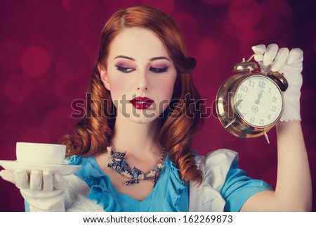 Portrait of a young redhead woman dressed as Alice in Wonderland, video game. Royalty-Free Stock Photo #162269873