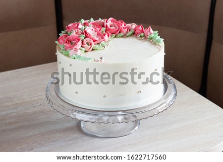 white round cake with cream flowers on the table.