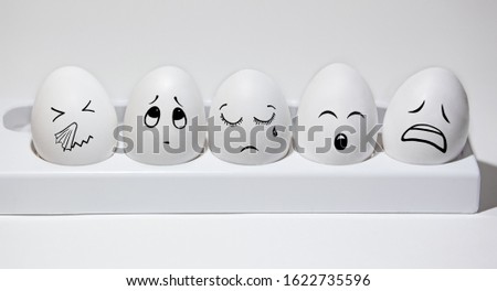 white eggs on a stand, emotions painted on faces, Easter concept