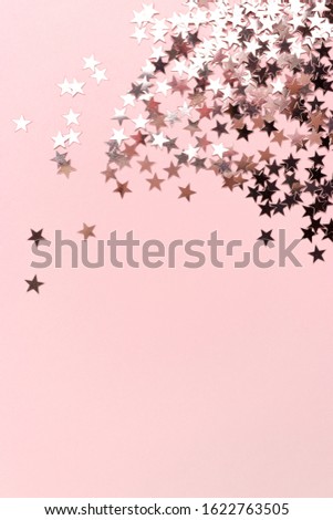 Stars glitter scattered on pink pastel background. Monochromatic concept with place for your text.