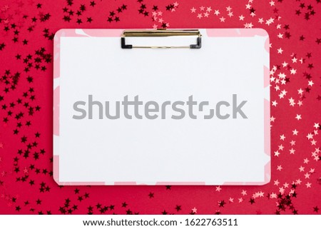 Clipboard mockup with blank paper. Shiny stars scattered on red background. 