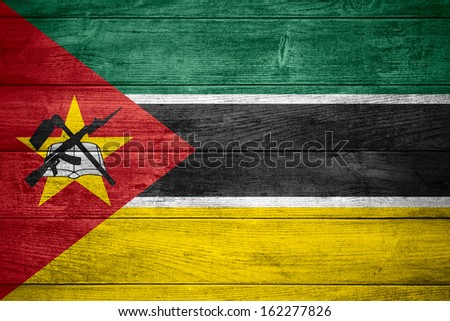 flag of Republic of Mozambique or  banner on wooden background