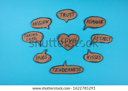 Components of love written on the cartoon bubbles on the blue background. Celebrating Valentines day concept. Tenderness, hugs, passion, taking care, trust, romance, respect, kisses.
