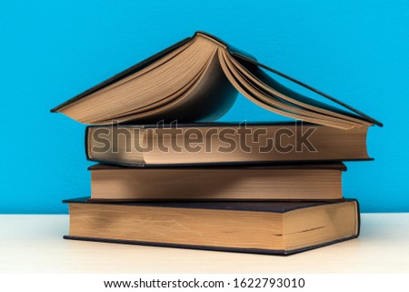 Heap pile of rare books. Open book, hardback books on wooden table. Education background. Back to school. Copy space for text. Bestseller, business. Stack of colorful books
