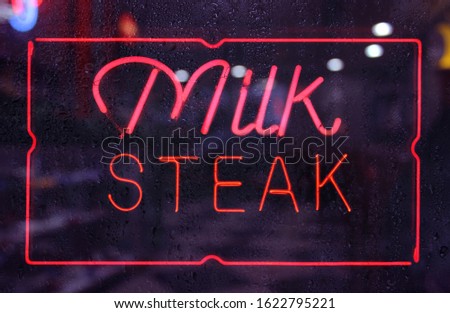Vintage Neon Milk Steak Sign in rainy window