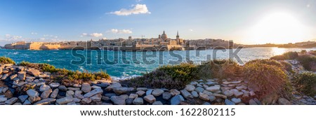 Panorama of Valletta, seafront skyline of the capital city of Malta with the St. Pauls Cathedral and The Basilica of Our Lady of Mount Carmel and green Mediterranean sea region vegetation, Malta
