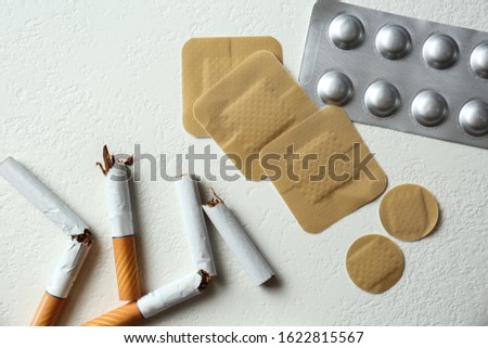 Nicotine patches, pills and broken cigarettes on white background, flat lay Royalty-Free Stock Photo #1622815567