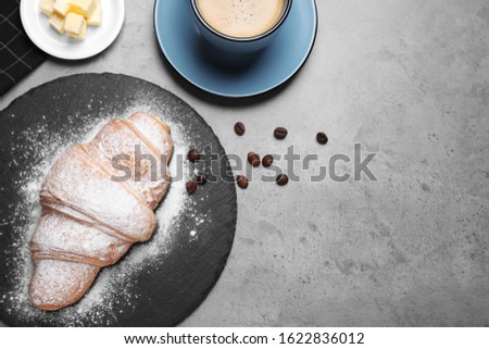 Flat lay composition with tasty croissant on grey table, space for text