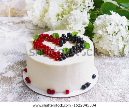 Round white cake with berries in the form of hearts, Valentine's Day, on white background. Picture for a menu or a confectionery catalog. Top view.