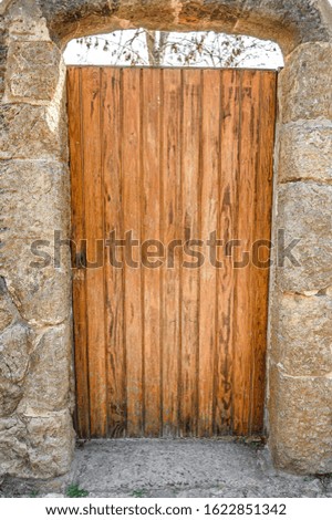 old wooden door in a stone wall. Barcelona, Spain. Catalonia