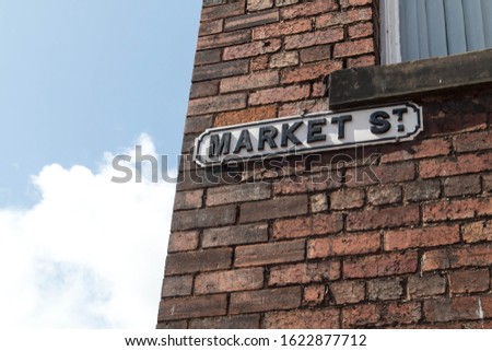 Market Street road sign on an old brick wall of a house.