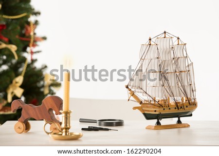 Vintage Wooden Horse and Ship on Santa's work table, Christmas Tree on background