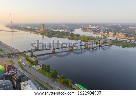 Aerial view photo from flying drone panoramic to railway bridge over Daugava river in Riga. Holiday time in Latvia. Warm summer in Baltic States. (series)