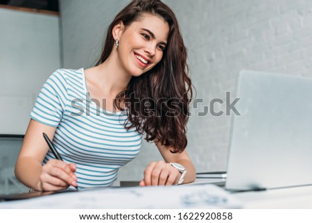 selective focus of happy animator looking at laptop