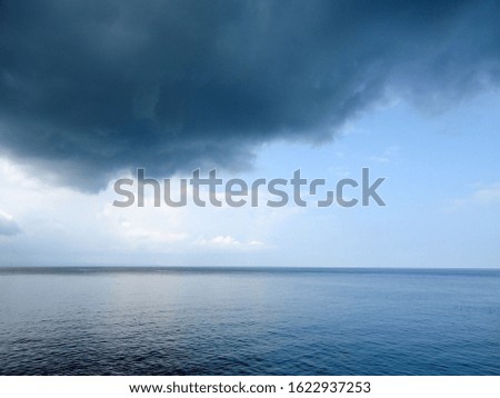 Cloudy summer day on the sea in Sithonia, Greece. Dark cloud and dark blue sea. Sea before the storm.