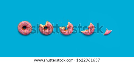Soft strawberry Donut food photo, break time. Delicious on blue background.Flat lay. Pink snack for party. With colorful sprinkles. 