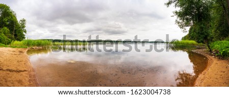 Panoramic view of the lakeshore on a cloudy day. Royalty-Free Stock Photo #1623004738