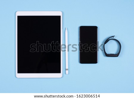 Modern gadgets on a blue background. Still life with modern technology on a plain blue background.