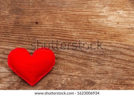 Love concept for Valentines day or mothers day. Card with space for text. Red felt heart, old wooden boards background, copy space, top view