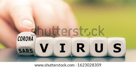 Hand turns a dice and changes the expression "sars virus" to "corona virus". Royalty-Free Stock Photo #1623028309