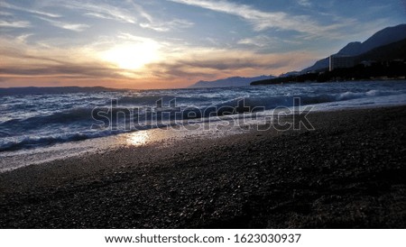 seashore with windy waves and warm sunset