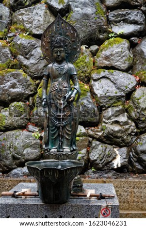 Japan water spring from steel statue of god woman.