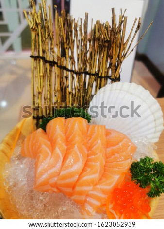Fresh Salmon Sashimi on ice in wooden bowl, Japanese food style.