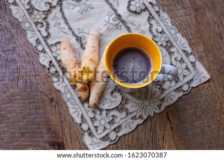 cheese bread on a stick with cup of coffee seen from above