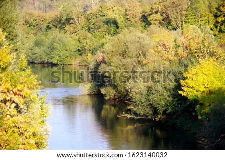 idyllic river in southern Germany with autumn trees on both banks,