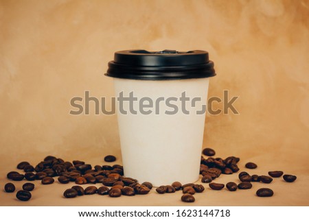 Coffee take away cup and coffee beans. Blank space for logo on  container. 