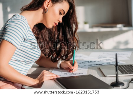 side view of illustrator drawing cartoon character on paper