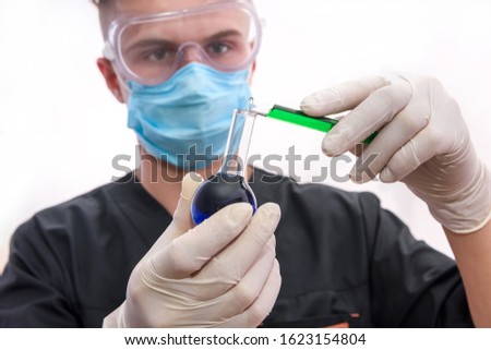 Chemist in laboratory with test tube examining it isolated on white background