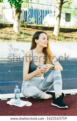 european woman sitting on the ground with a bottle of water