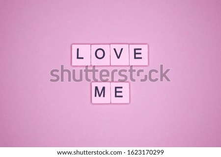 Love me word wooden cubes on a pink background