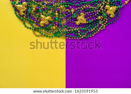 Mardi gras decoration beads with fleur-de-lis. Colorful holidays flat lay background
