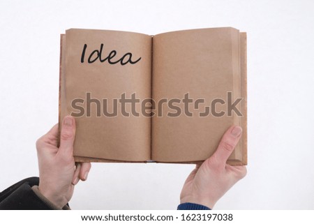 An idea written in a book in the hands of a man on a background of snow.