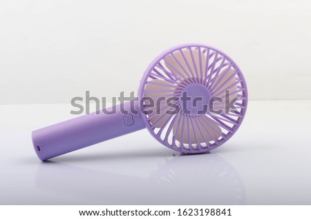 Purple portable mini fan on white background. Selective focus. 