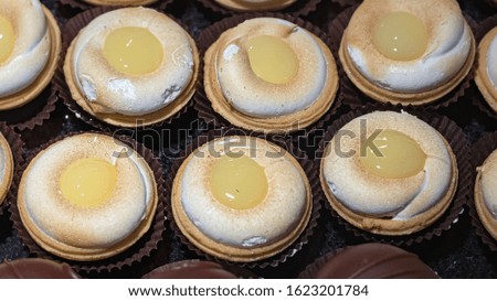 Small meringue tarts with lemon cream on top, top view.