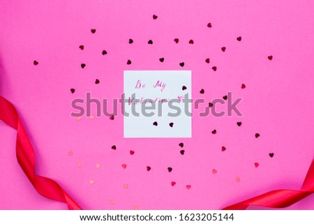 Card Will you be my valentine on pink background surrounded by hearts and a red ribbon