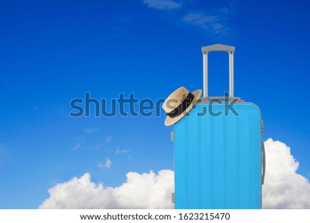 Blue luggage and straw hat